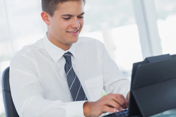 Cheerful young businessman working on his tablet pc Royalty Free Stock Photos