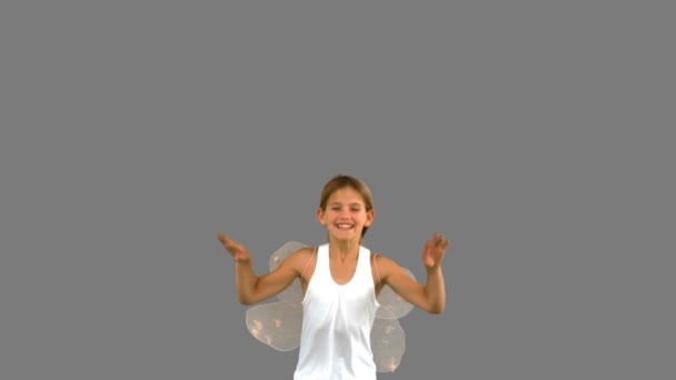 Girl wearing dragonfly wings and jumping on grey screen — Stock Video