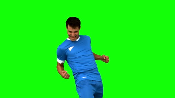 Cheerful football player gesturing on green screen — Stock Video