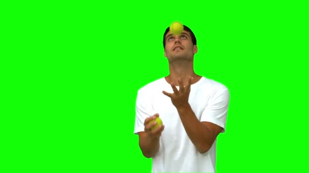 Handsome man dribbling with balls on green screen — Stock Video