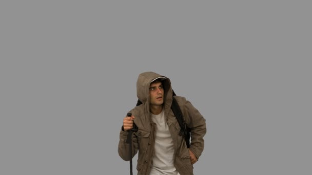 Hombre con abrigo trekking en pantalla gris — Vídeo de stock