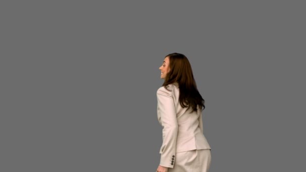 Businesswoman jumping and giving thumbs up on grey screen — Stock Video