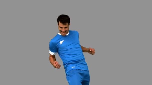 Cheerful football player gesturing on grey screen — Stock Video