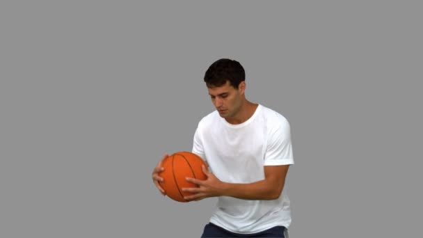 Adam gri ekran üzerinde bir basketbol ile top sürme — Stok video