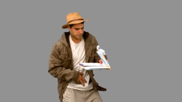 Homem com um mapa e uma bússola de orientação em tela cinza — Vídeo de Stock