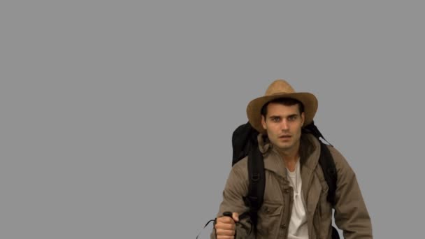 Muž s kloboukem, chůze v listí padá na šedé obrazovce — Stock video