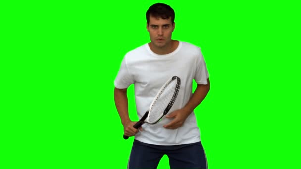 Bonito homem treinando enquanto joga tênis na tela verde — Vídeo de Stock