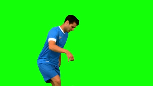 Bonito homem jogando com uma bola de futebol na tela verde — Vídeo de Stock