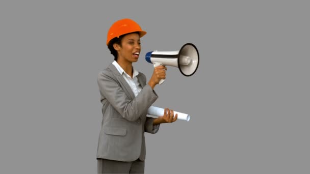 Happy architect using a megaphone on grey screen — Stock Video