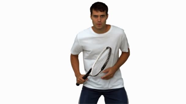 Hombre guapo entrenando mientras juega al tenis en pantalla blanca — Vídeos de Stock