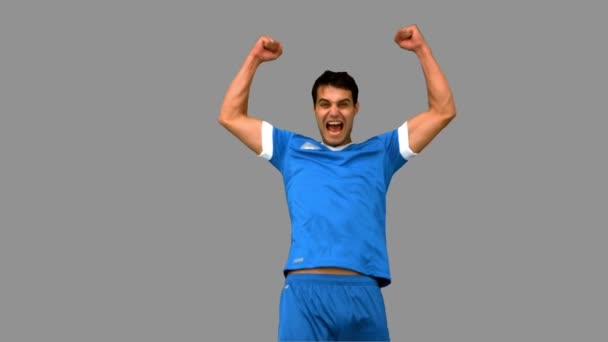 Glücklicher Fußballspieler, der auf grauer Leinwand die Arme hebt — Stockvideo