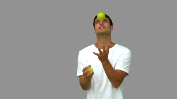 Handsome man dribbling with balls on grey screen — Stock Video