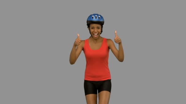 Ciclista mujer dando pulgares hacia arriba en la pantalla gris — Vídeo de stock