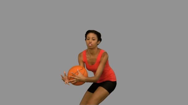 Mujer atrapando y lanzando una pelota de baloncesto en pantalla gris — Vídeos de Stock