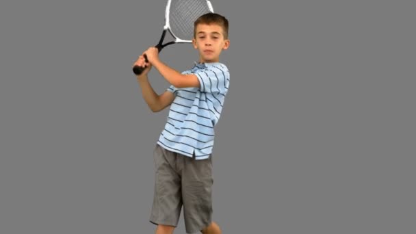 Kleine jongen tennissen op grijs scherm — Stockvideo