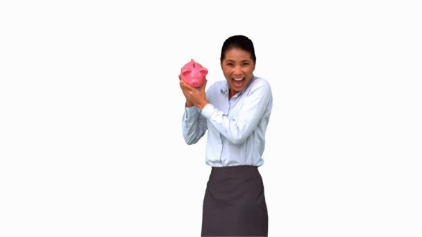 Affärskvinna som skakar en full spargris på vit skärm — Stockvideo