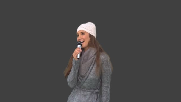 性格开朗年轻模型在冬天的衣服在麦克风上唱歌 — 图库视频影像