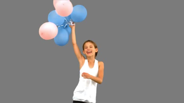 Niña jugando con globos en pantalla gris — Vídeos de Stock