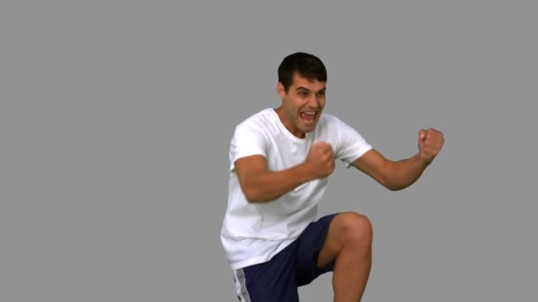 Homem feliz gesticulando na tela cinza — Vídeo de Stock
