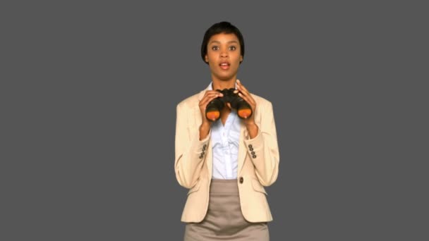 Concentrated businesswoman jumping while holding binoculars — Stock Video