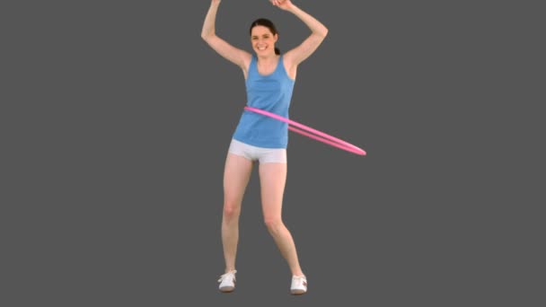 Молодая модель в спортивной одежде танцует хула-хуп — стоковое видео