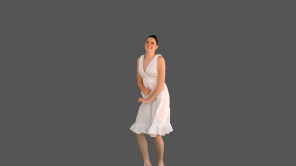Jolie jeune mannequin en robe blanche sautant — Video