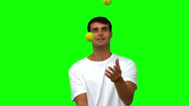 Чоловік дриблінг з тенісними м'ячами на зеленому екрані — стокове відео