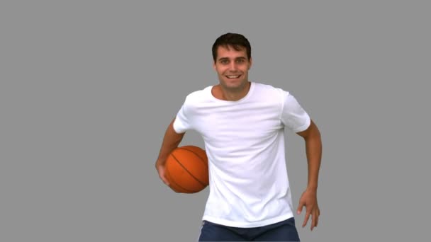 Man playing and dribbling with a basketball on grey screen — Stock Video