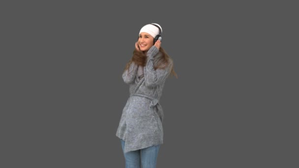 Cheerful young model in winter clothes listening to music — Αρχείο Βίντεο