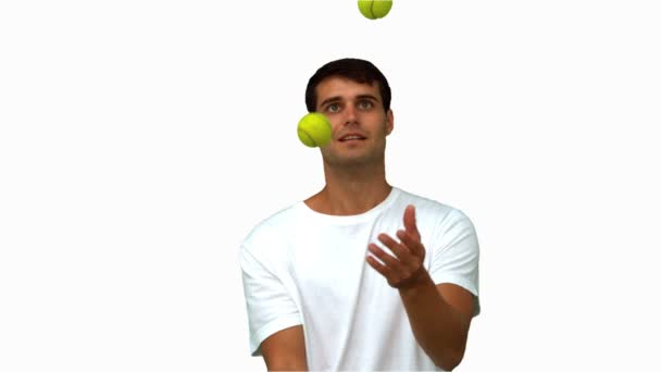 Man dribbling with tennis balls on white screen — Stock Video