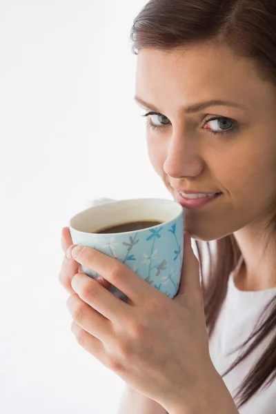 Menina pensativa olhando para a câmera e bebendo uma xícara de café — Fotografia de Stock