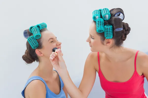 Amigos em rolos de cabelo se divertindo com maquiagem — Fotografia de Stock