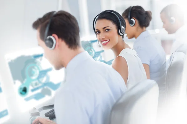 Attractive call centre employee looking over shoulder — Stock Photo, Image