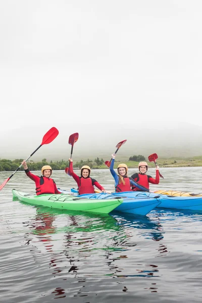 Glückliche Freunde auf einem See rudern — Stockfoto