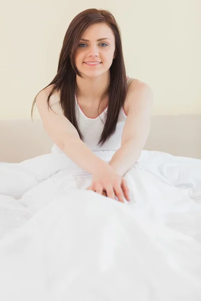 Awakened girl sitting in her bed looking at camera — Stock Photo, Image