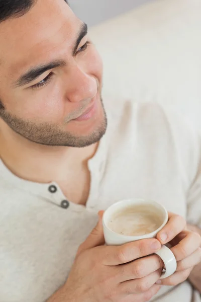 一杯のコーヒーを保持笑みを浮かべて思慮深い男 — ストック写真