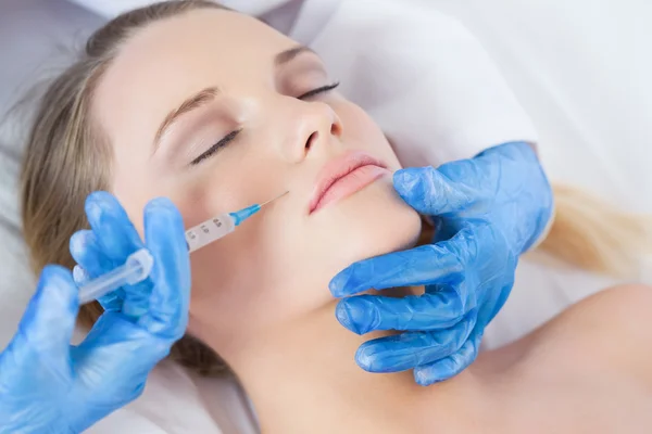 Surgeon making injection above lips on woman lying — Stock Photo, Image