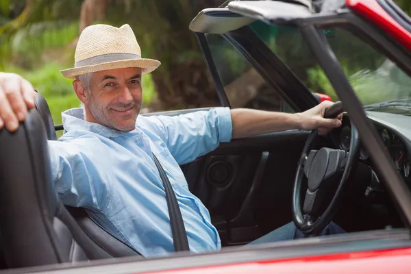 Smiling handsome man posing in red convertible — Stock Photo, Image