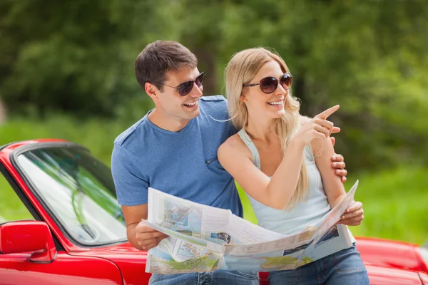 Cheerful young couple reading map — Stock Photo, Image