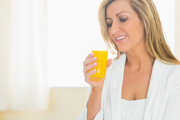 Leende kvinna njuter av ett glas apelsinjuice — Stockfoto