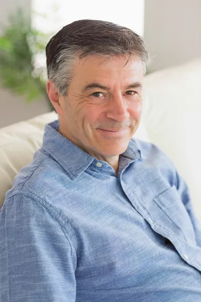 Smiling man on a sofa — Stock Photo, Image