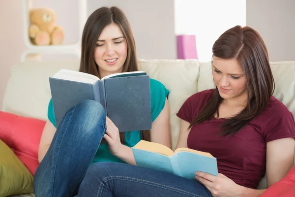 Two girls reading books on the couch — Stock Photo, Image