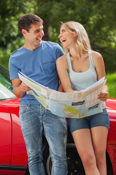 Smiling young couple reading map — Stock Photo, Image