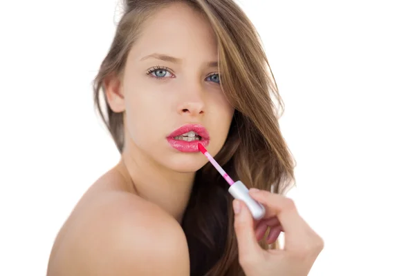 Brunette model toepassen glans op haar lippen gericht — Stockfoto