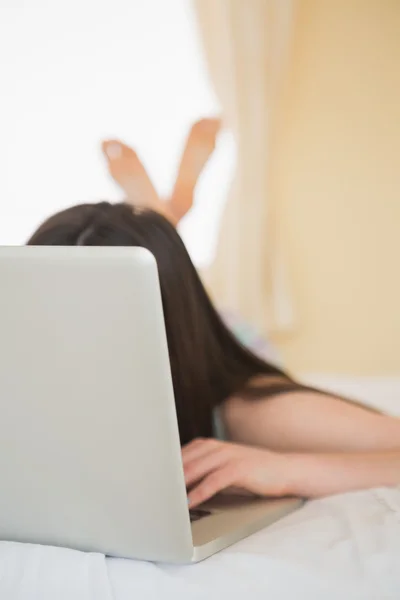 Laptop covering girls face on bed — Stock Photo, Image