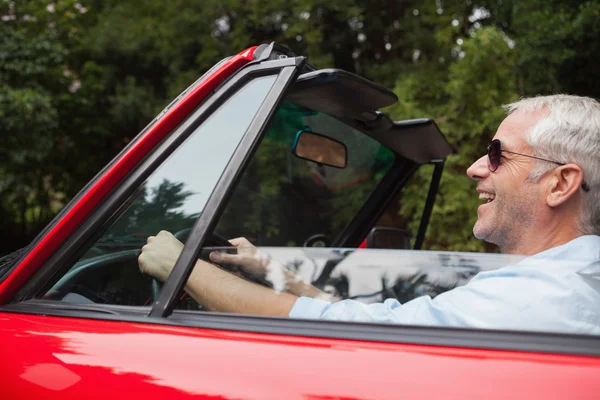 Sorridente bell'uomo guida rosso convertibile — Foto Stock