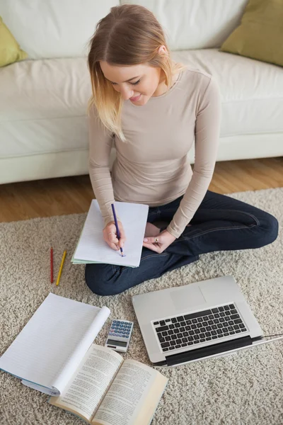 Leende kvinna som arbetar på läxor — Stockfoto