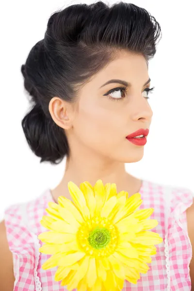 Modelo de pelo negro reflexivo sosteniendo una flor y mirando hacia otro lado — Foto de Stock