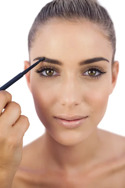 Conteúdo mulher aplicando maquiagem em suas sobrancelhas — Fotografia de Stock