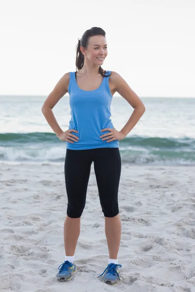 Brunette woman wearing sport wear in front of ocean — Stock Photo, Image